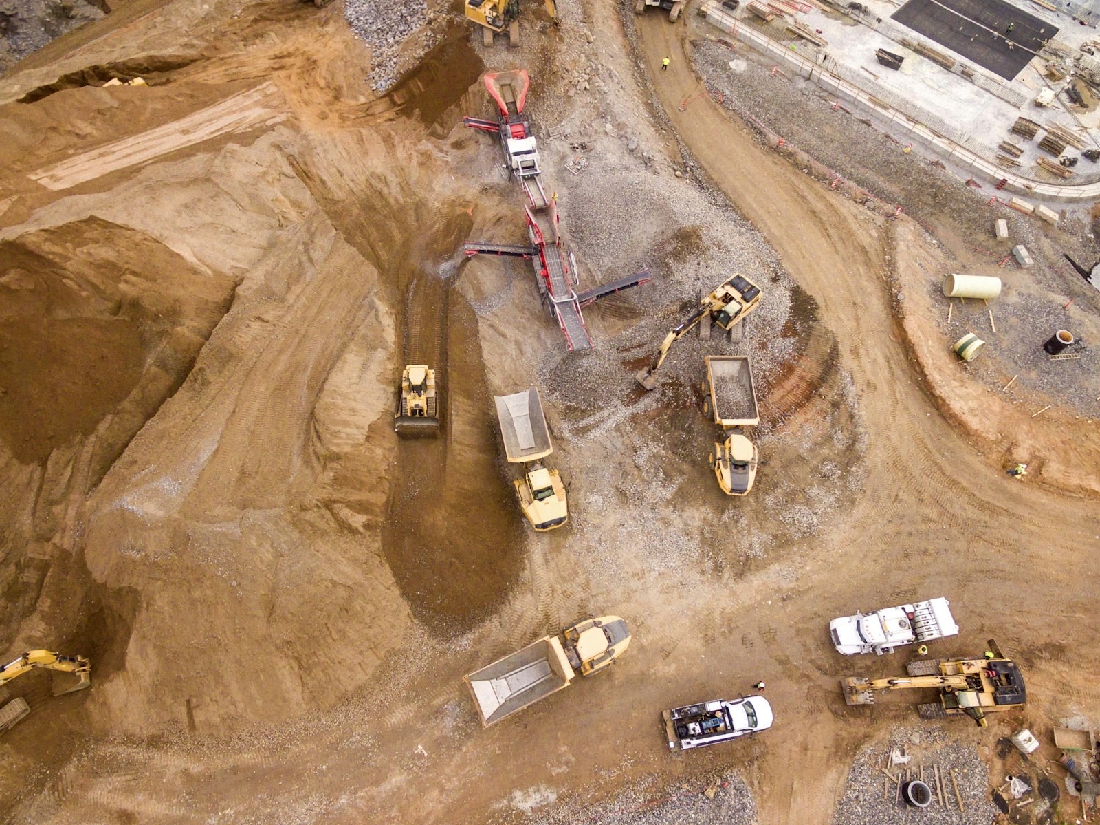 Aerial view of an excavation site with earth-moving machinery working the ground