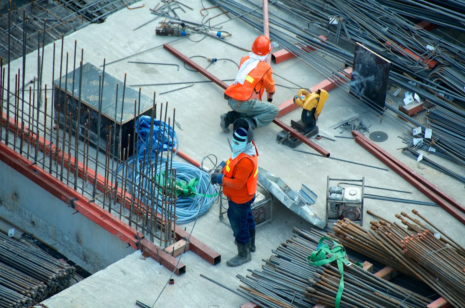 Construction workers laying services and conduits on a concrete deck before a utility survey
